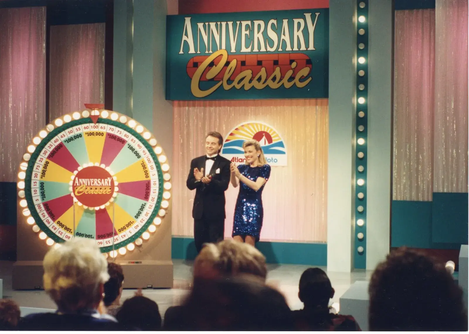 Vanna White et un animateur sur le plateau de l’émission marquant notre anniversaire, à côté d’une roue de prix